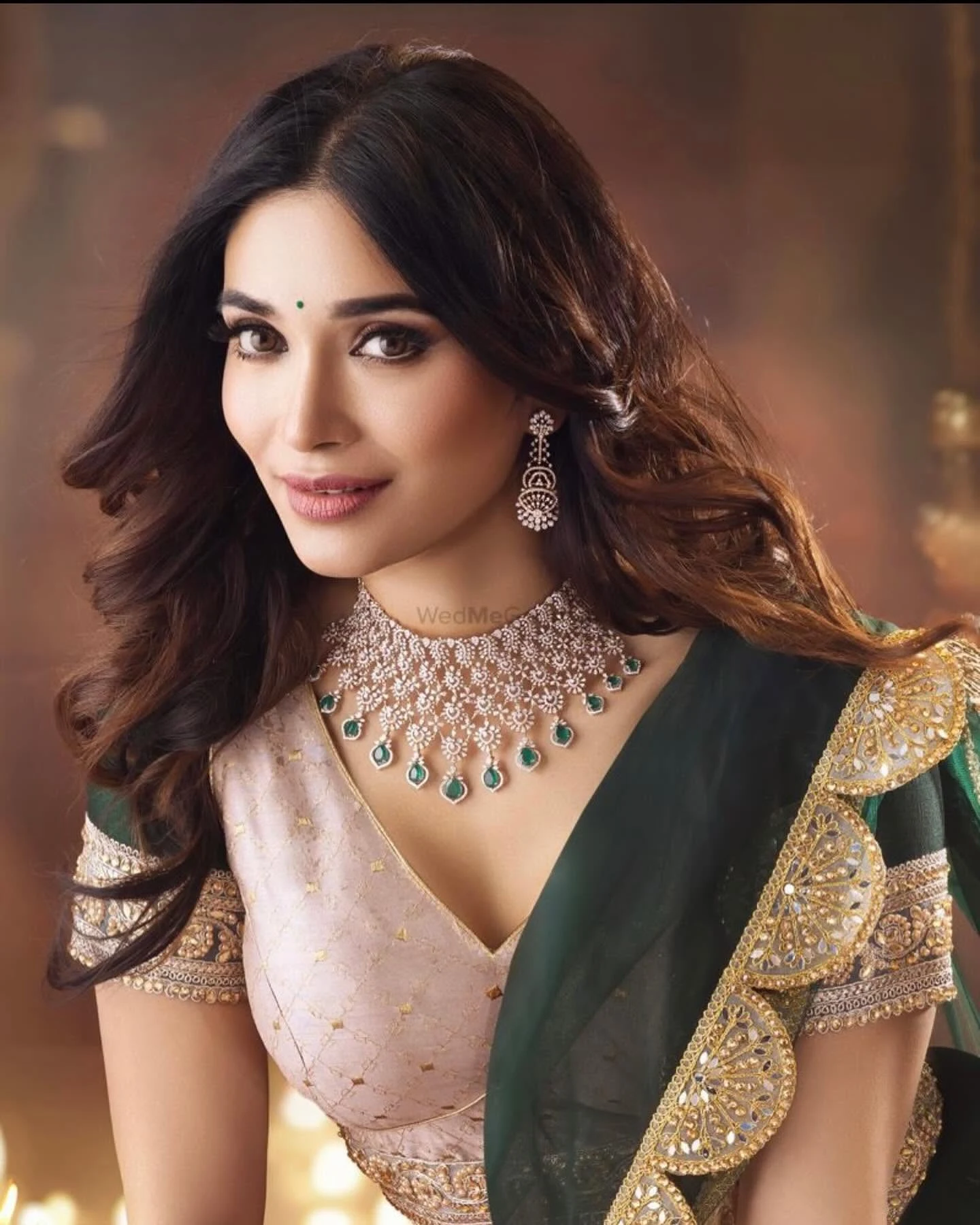 Portrait in an emerald green drape with flowing hair and a sparkling jewellery set.